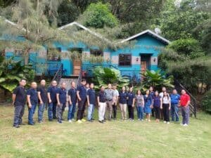 A group of people standing in front of a blue house.