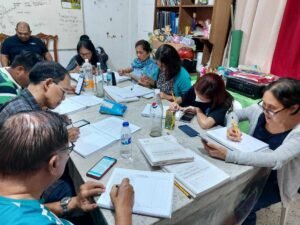 A group of people sitting around a table with papers.