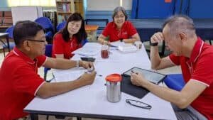 A group of people in red shirts sitting at a table.