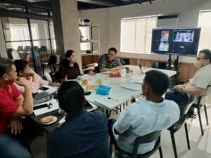 A group of people sitting around a table in a conference room.