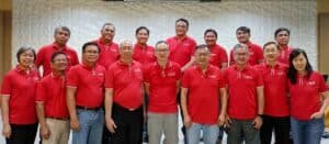 A group of men in red shirts posing for a photo.